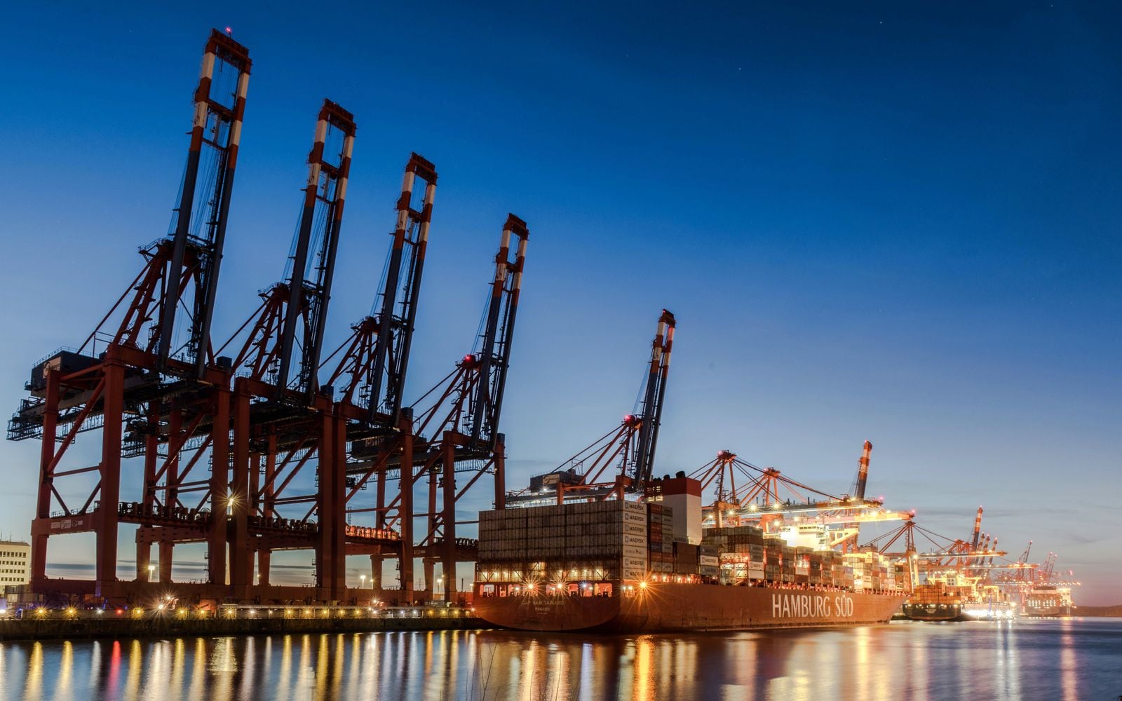 Containerterminal met kranen in de avond